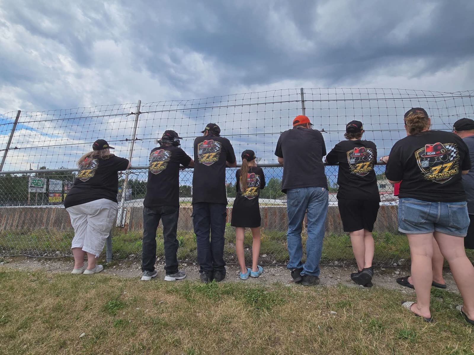 Ayden McNicol Racing supporters wearing team gear along the race track fence